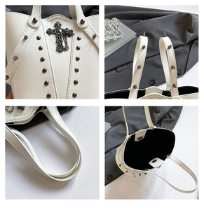 Detail view of white bucket bag featuring black studs, cross pendant and magnetic closure