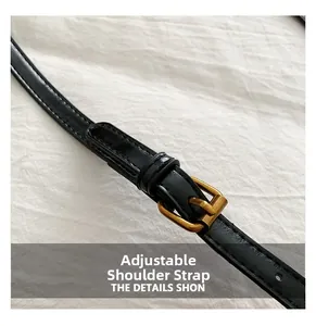 Dettaglio della tracolla regolabile in pelle nera con fibbia in bronzo sulla borsa