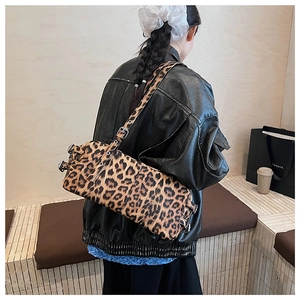 Détail du sac cylindrique à imprimé léopard avec bandoulière en cuir et métal