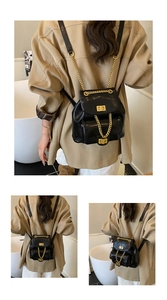 Detail eines schwarzen Vintage-Rucksacks mit goldenen Ketten und Metallverschluss