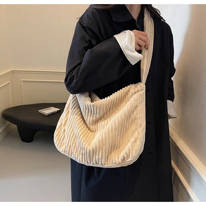 Detail of cream corduroy tote bag showing textured vertical stripes and wide shoulder strap