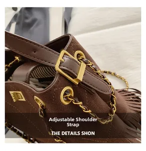 Détail du sac à main marron foncé mat avec boucle dorée et décoration de glands