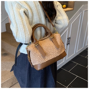 Détail du sac à main en peluche beige avec base en cuir marron et picots de protection