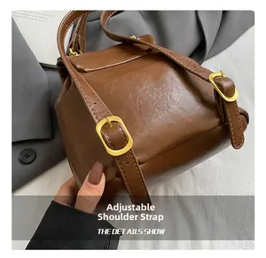 Detail der verstellbaren Schultergurte am braunen Lederrucksack mit Gold-Schnalle