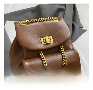 Detailaufnahme der braunen Leder-Beuteltasche mit Goldkette und Drehverschluss