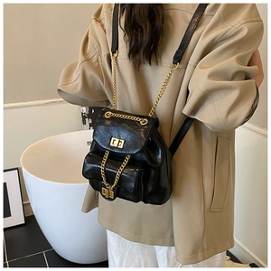 Detail eines schwarzen Mini-PU-Lederrucksacks mit goldenen Ketten auf dem Rücken