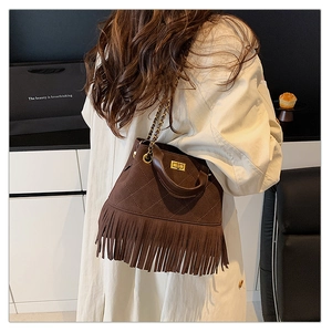 Détail du sac seau en daim marron foncé avec franges et surpiqûres matelassées