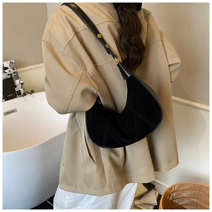 Détail du sac demi-lune en daim noir avec surpiqûres et bandoulière réglable