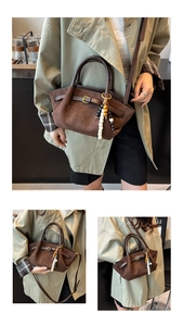 Detail of brown matte suede bucket bag with beaded charm and versatile strap options