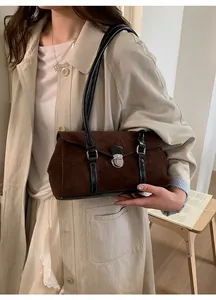 Detail of vintage suede shoulder bag with black leather trim and silver metal buckle