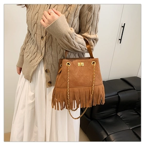Détail du sac seau marron en daim à franges avec matelassage et bandoulière en chaîne dorée