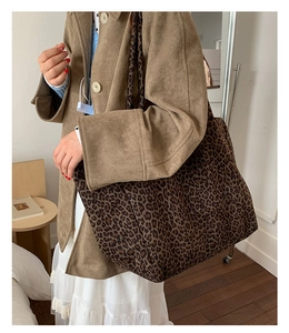 Gros plan d'un grand sac cabas léopard en daim avec une large bandoulière sur un modèle