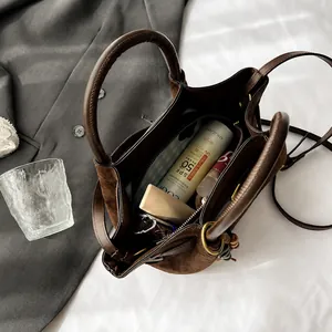 Interior view of brown bucket bag showing spacious storage with cosmetics and zipper pouch