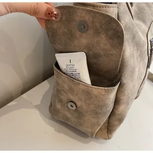 Detailed view of the vintage brown tote bag side pocket with magnetic flap closure
