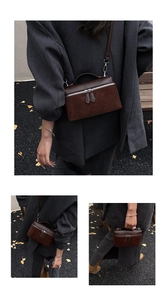 Détails du sac boîte marron foncé montrant la texture en daim et cuir lisse avec zips