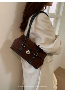 Detail shot of vintage dark coffee suede underarm bag with silver round twist lock buckle
