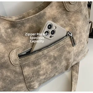 Detail shot of the vintage brown tote bag showing a side zipper pocket with a phone inside