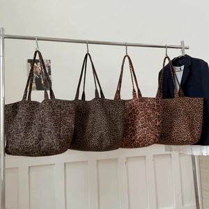 Various leopard print canvas tote bags with large capacity on metal display rack