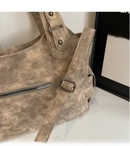 Detail of adjustable long shoulder strap and vintage texture on the large tote bag
