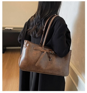 Detail of vintage brown shoulder bag with decorative straps and metal buckle