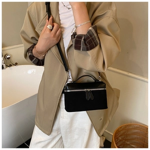 Gros plan du sac bandoulière en velours noir avec zips argentés et fine bandoulière