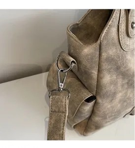 Detail of vintage tote bag with frosted brown texture and glossy metal D-ring buckle