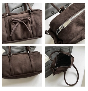 Detalle del bolso Boston de ante marrón oscuro con lazo, cremallera plateada y bolsillo interior
