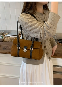 Detail showing the brown suede underarm bag with silver buckle and black leather strap