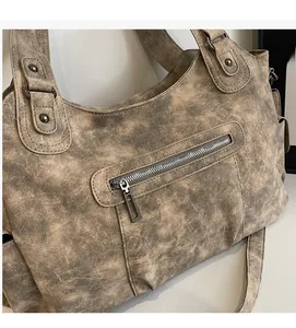 Detail of vintage tote bag showing washed PU leather texture and metal zipper pocket