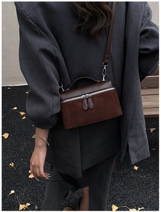 Détail d'un sac bandoulière patchwork en daim marron foncé au style automnal chic