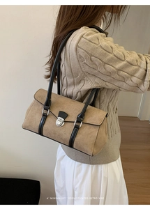 Detail of retro suede shoulder bag with black leather straps and silver buckle closure