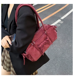 Detalle de bolso de hombro de ante burdeos con lazo y textura de estilo urbano