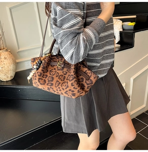Detail of leopard print bucket bag featuring retro leather strap and beaded charm