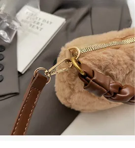 Détail de la quincaillerie dorée et de la texture pelucheuse du sac bandoulière kaki
