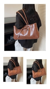 Detailed back view of a brown vintage leather tote bag shown on a shoulder in a cozy room