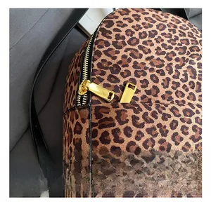 Detail eines Leoparden-Rucksacks mit hochwertigen Goldbeschlägen und Lederriemen