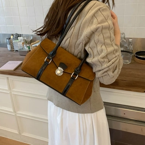 Detail of vintage brown suede shoulder bag with silver metal swivel lock and black straps