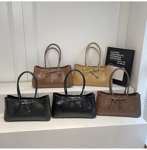 Collection of matte suede tote bags in earthy tones featuring a bow buckle and double straps