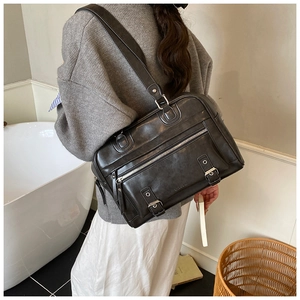 Detail view of the black retro leather shoulder bag with two front buckle pockets