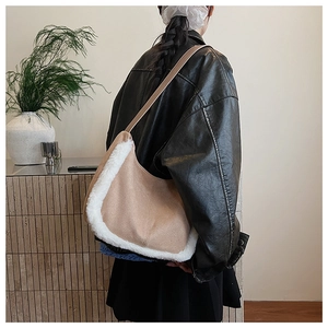 Detail of plush beige suede underarm bag showing fluffy white fur trim texture and strap
