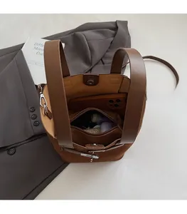 Internal view of brown suede bucket bag showing large capacity and zipper pocket
