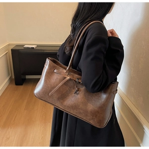 Detail shot of a dark brown suede tote bag showing its premium matte leather texture
