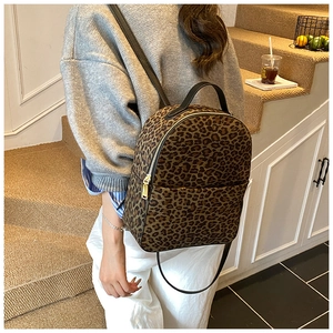 Detailansicht eines Leopard-Rucksacks mit goldenem Reißverschluss und Trägern