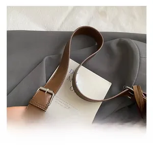 Close-up of adjustable dark brown leather shoulder strap with silver buckle on tote bag