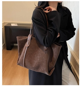 Detail of a large vintage brown tote bag worn on shoulder for stylish daily commuting
