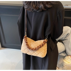 Détail du sac matelassé en peluche avec poignée tressée sur tenue d'automne