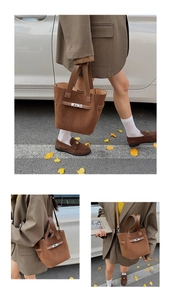 Detail of vintage brown suede bucket bag featuring metal twist lock and leather straps