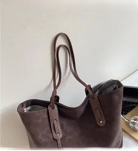 Detail of dark brown tote bag with reinforced long handles and smooth zipper closure