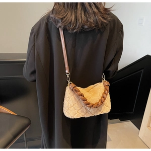 Détail du sac matelassé en peluche avec poignée tressée et texture en fausse fourrure