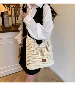 Detail of minimalist cream crochet tote bag with brown straps for summer beach